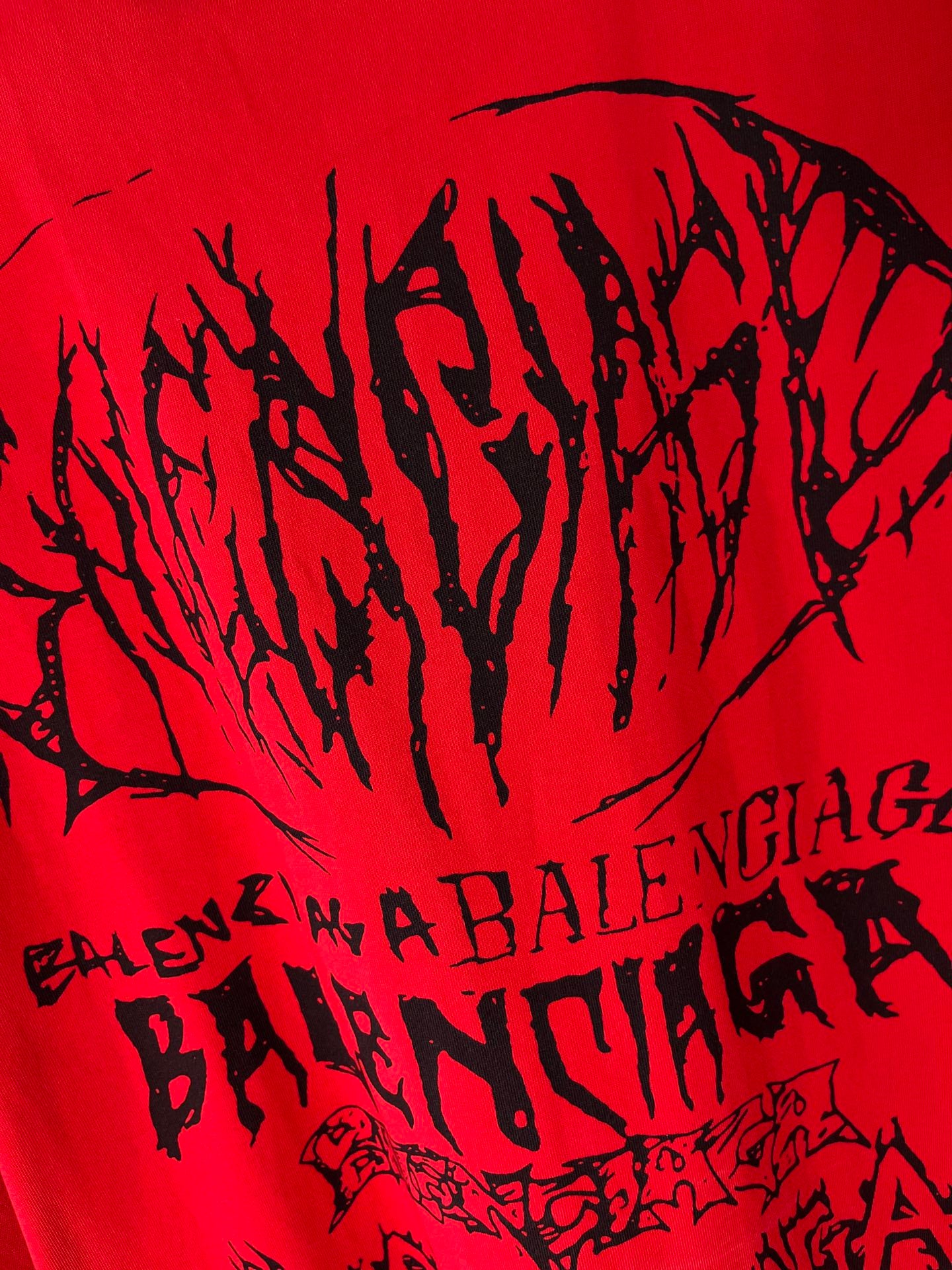 Red T-shirt close-up with large black graphic wordmark text
