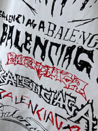 White T-shirt close-up with black and red graffiti-style lettering and emblem