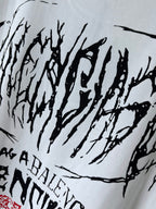 White T-shirt close-up with black graffiti-style text across the fabric