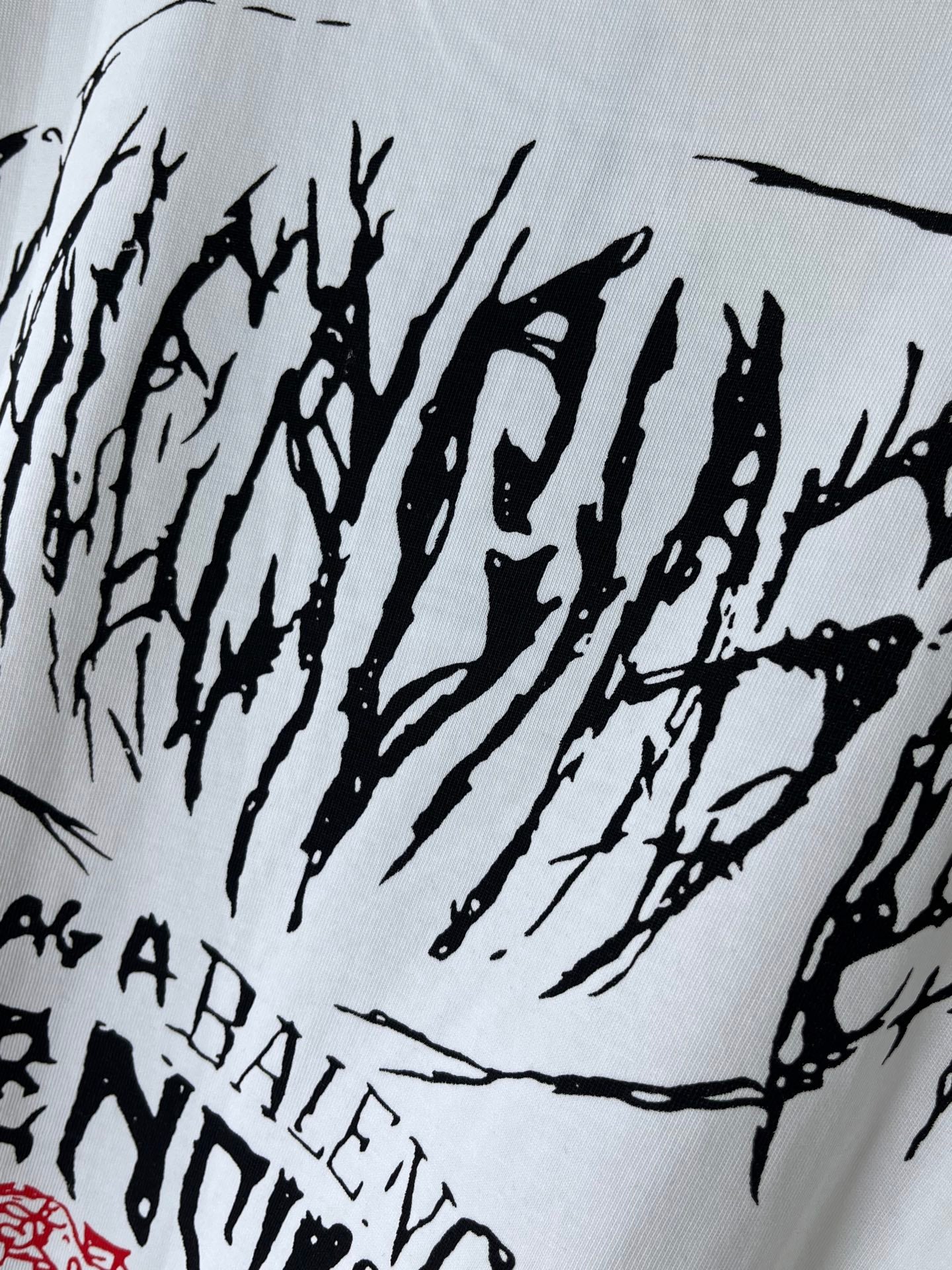 White T-shirt close-up with black graffiti-style text across the fabric
