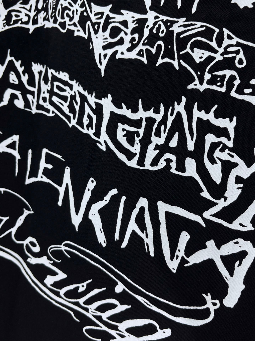 Balenciaga T-shirt fabric close-up, black with bold white graphic lettering