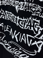 Balenciaga T-shirt fabric close-up, black with bold white graphic lettering
