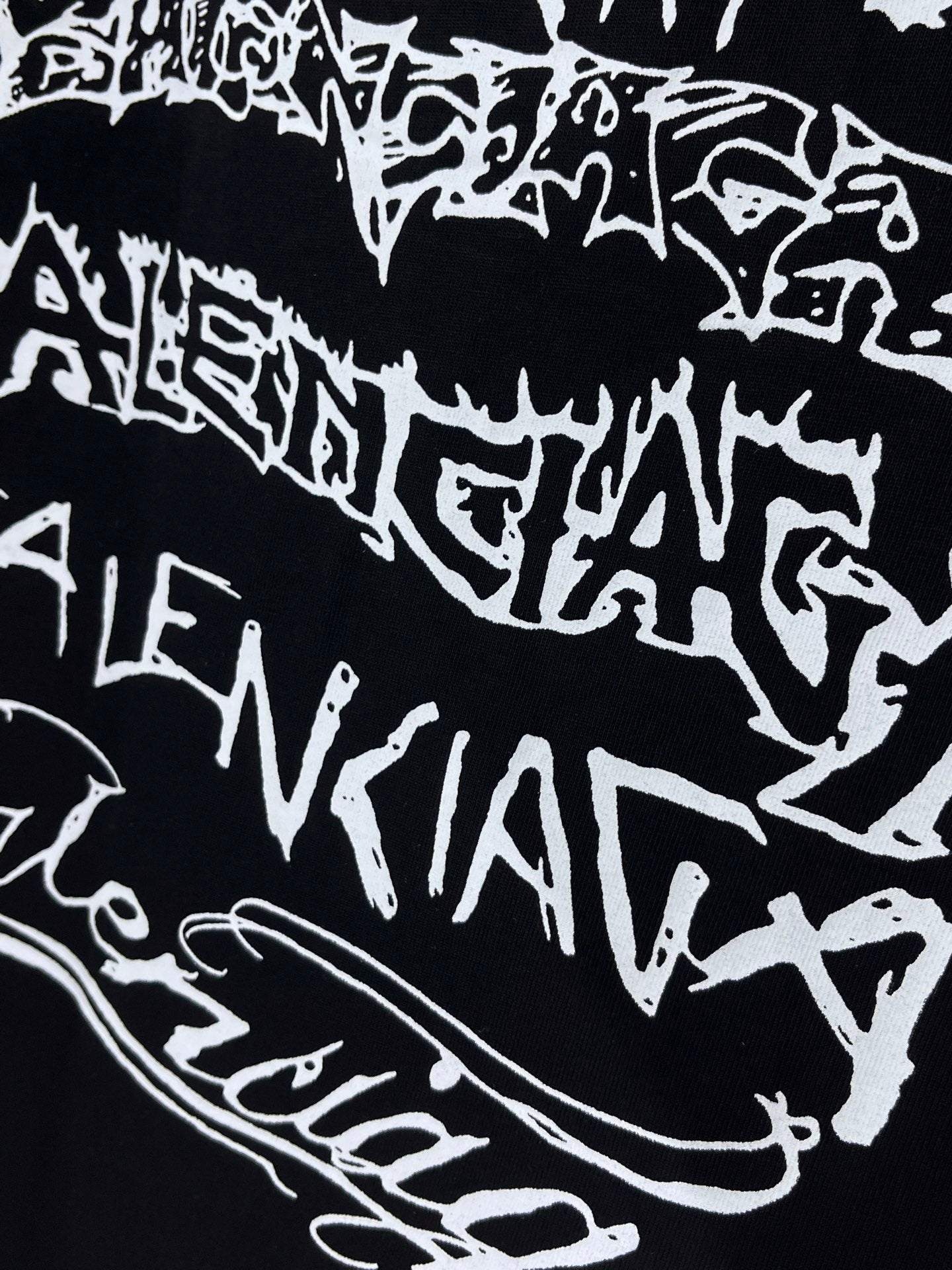 Balenciaga T-shirt fabric close-up, black with bold white graphic lettering