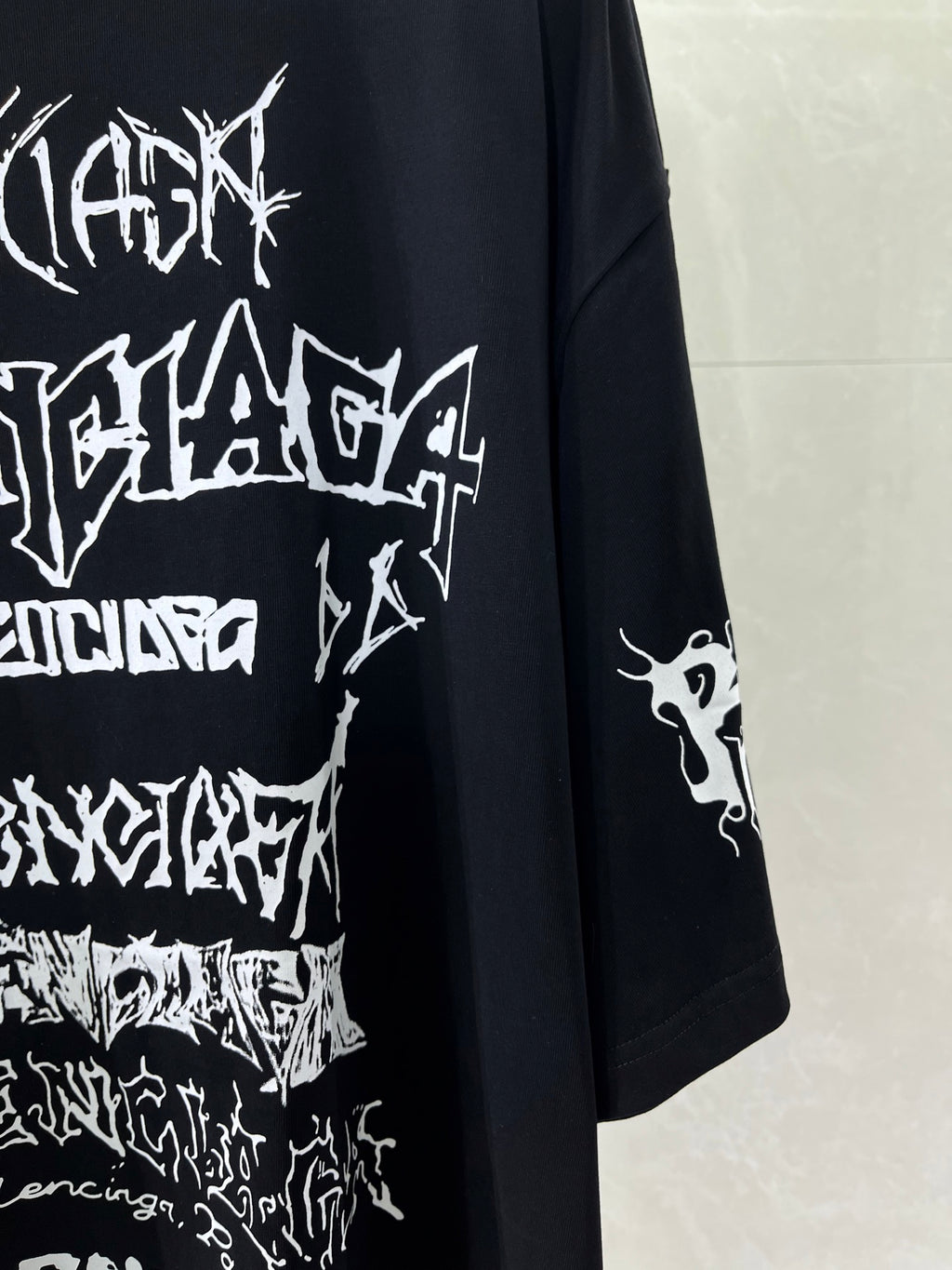Balenciaga T-shirt close-up with large white graphic print and printed sleeve