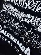 Balenciaga T-shirt pattern close-up, black with scattered white wordmark-style print
