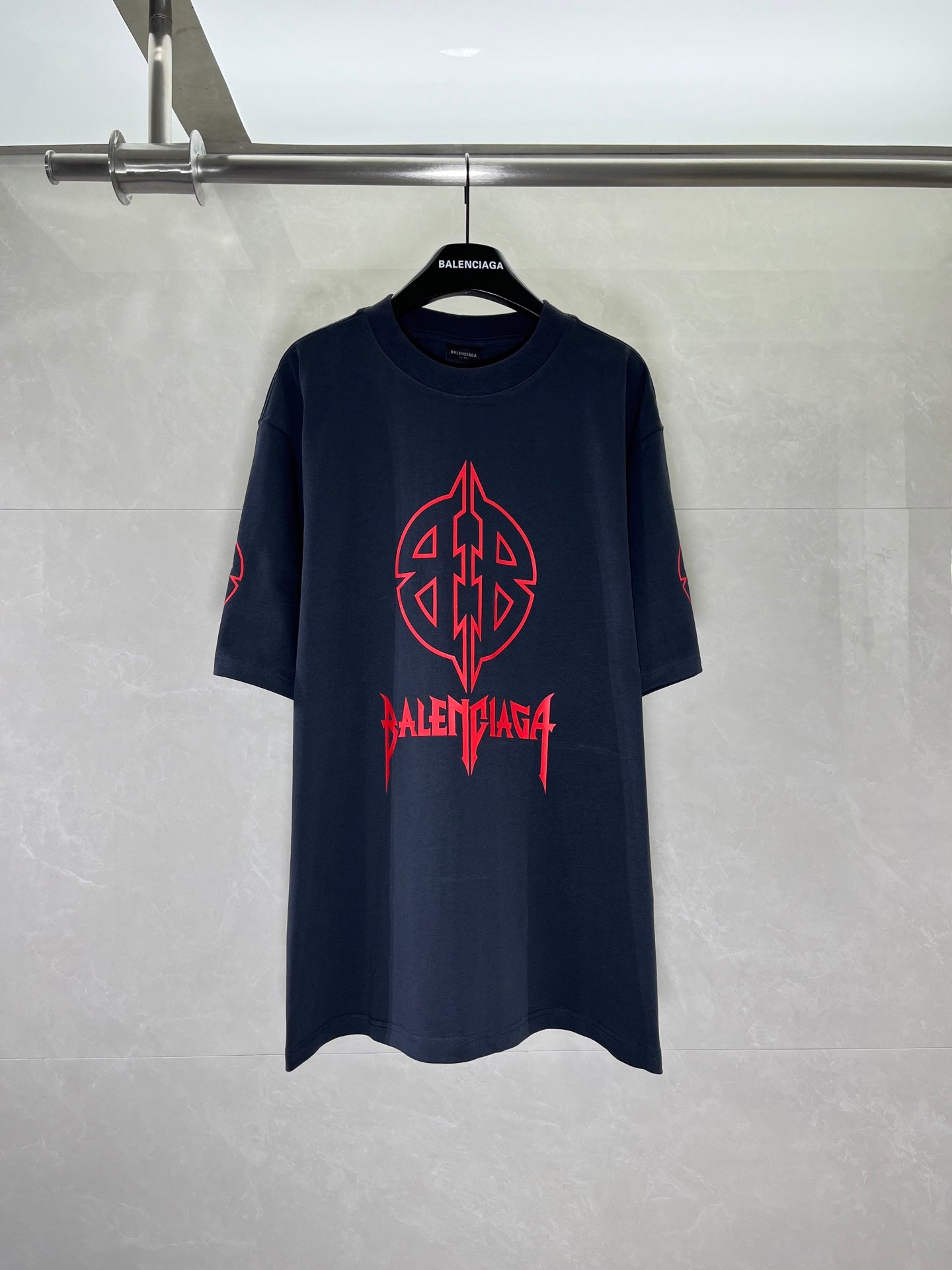 Graphic T-shirt with red front emblem, dark navy crew neck.