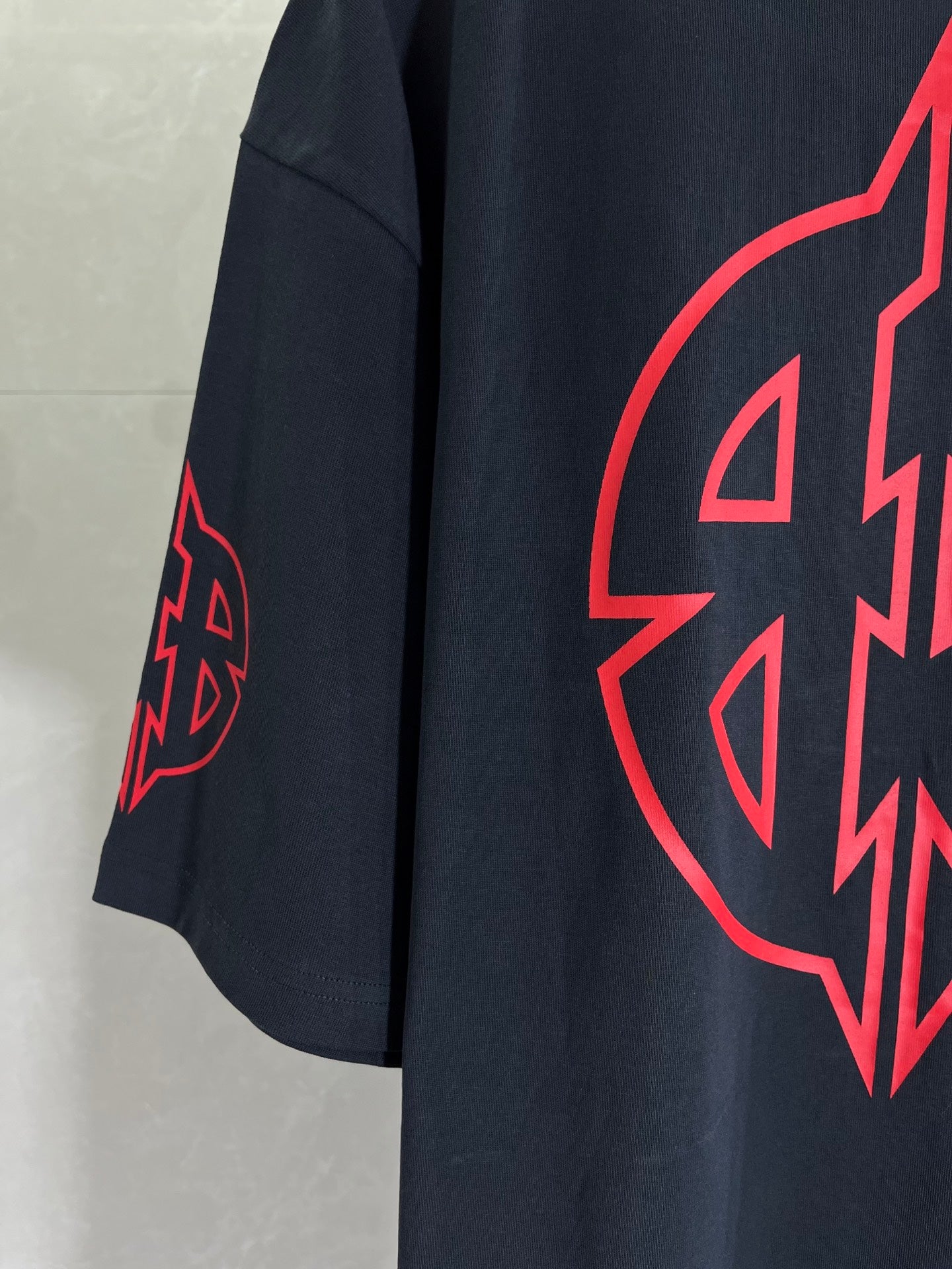 Dark navy T-shirt with red graphic emblem on the front side.