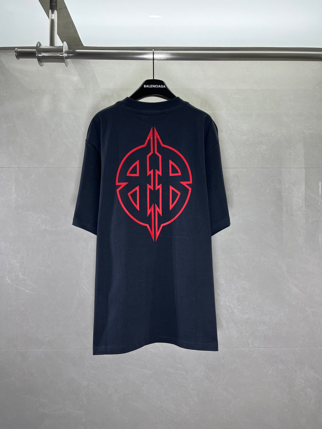 Graphic T-shirt with large red back emblem, dark navy crew neck.