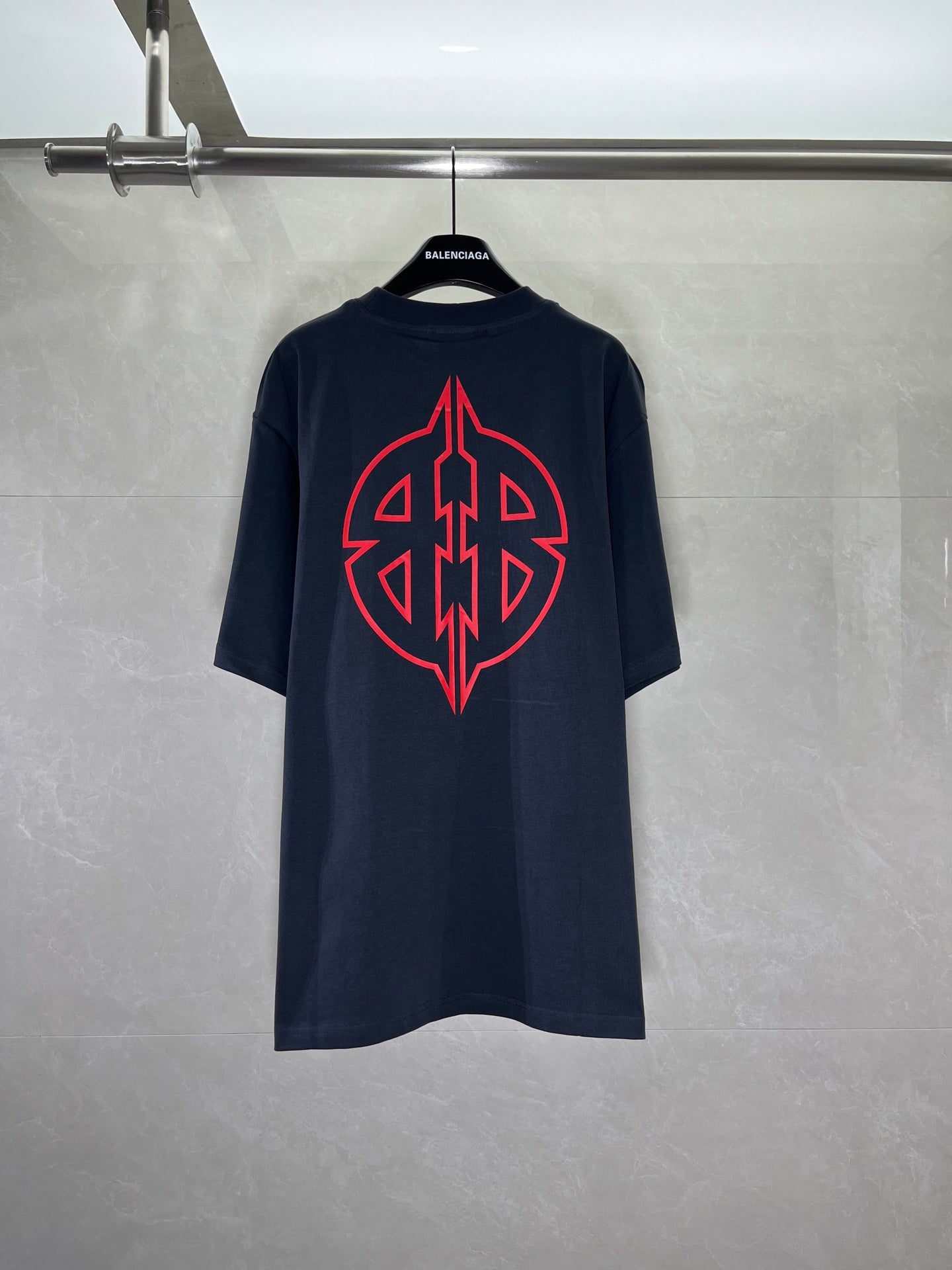 Graphic T-shirt with large red back emblem, dark navy crew neck.