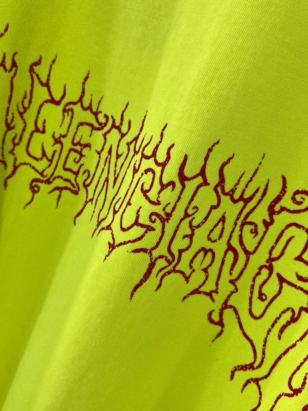 Lime green T-shirt back graphic close-up in dark red