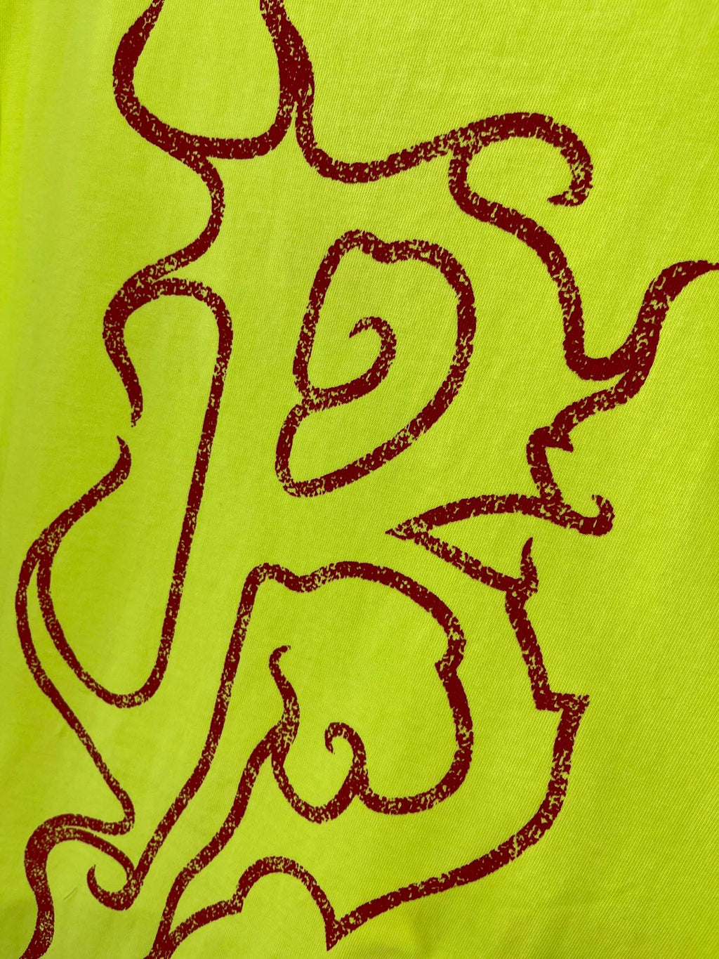 Lime green T-shirt graphic close-up with dark red line art