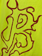 Lime green T-shirt graphic close-up with dark red line art