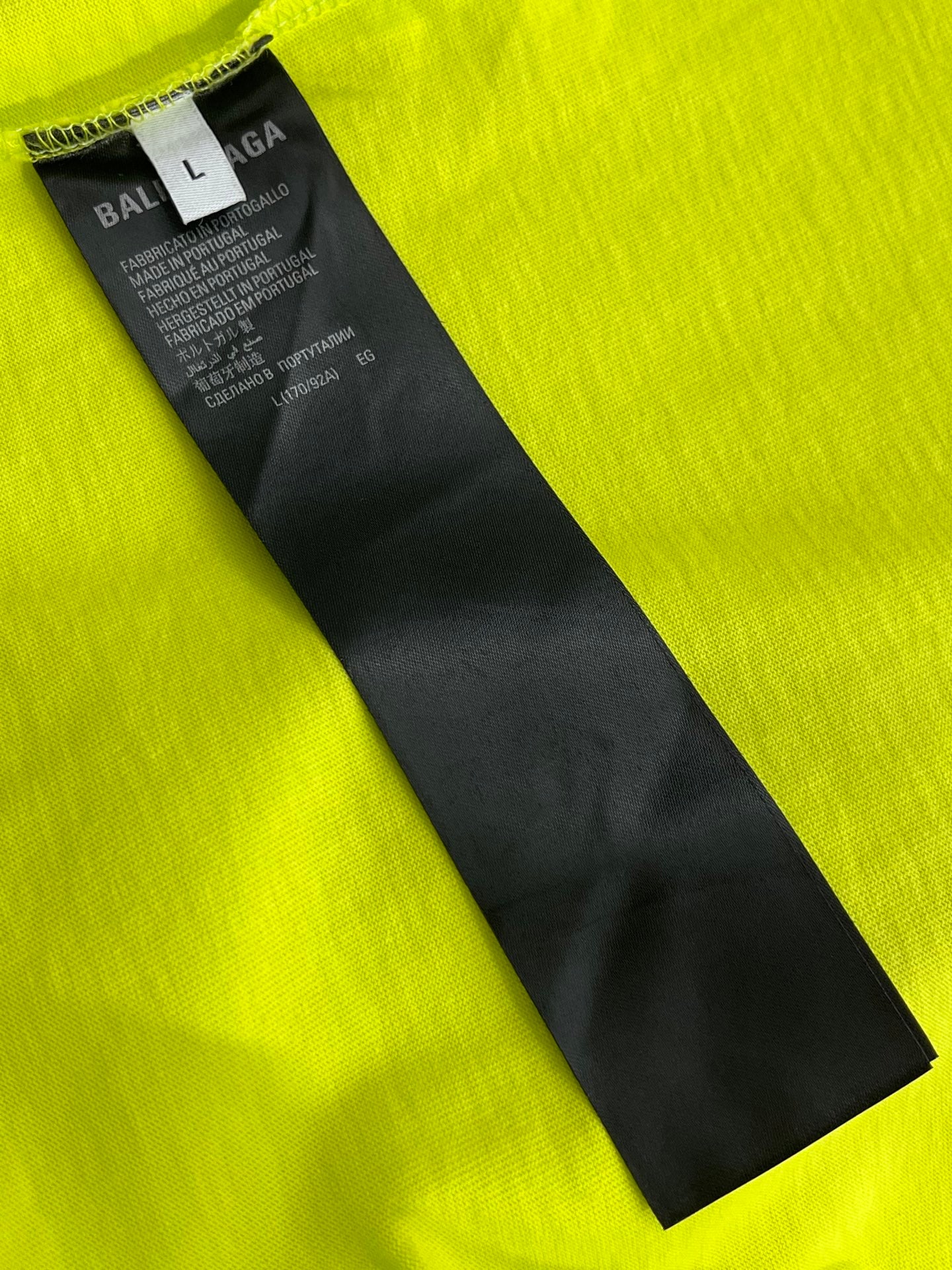 Lime green T-shirt neck label with size tag and Balenciaga branding
