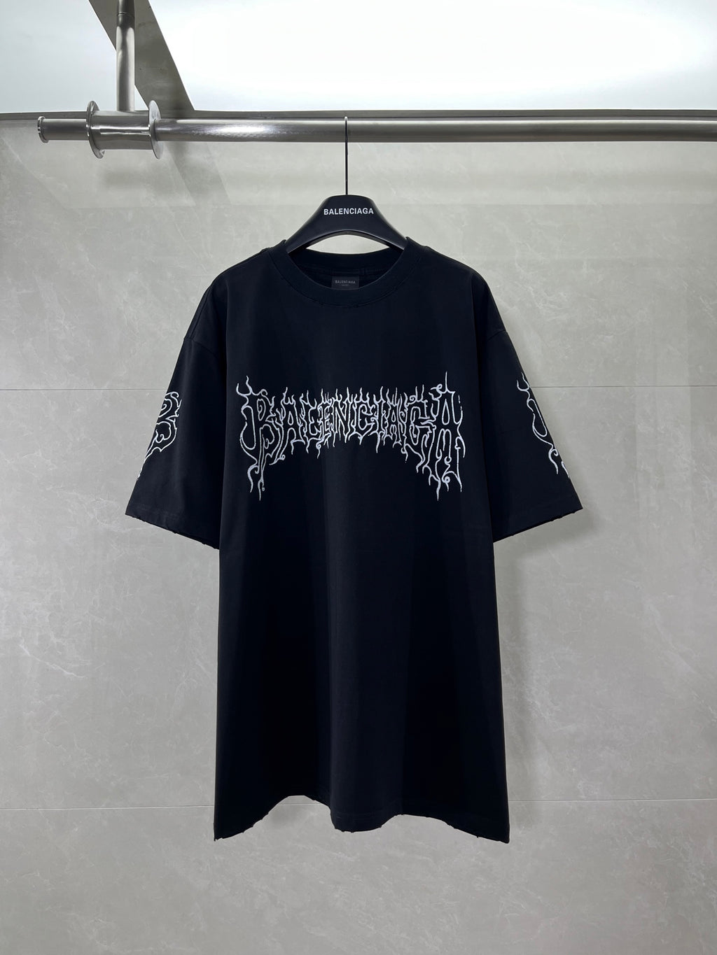 Black short-sleeve shirt with white graphic logo on front