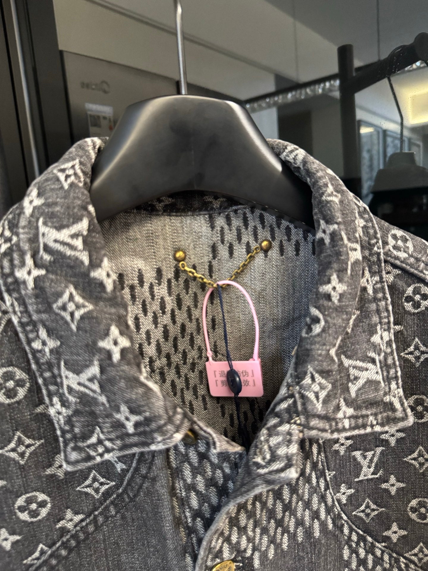 Louis Vuitton denim jacket close-up of check yoke and monogram collar, gold buttons