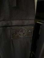 Stone Island logo patch on dark gray cargo trousers, stitched patch detail on pocket area