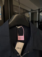 Dark navy jacket with stand collar and front zip, hang tags visible