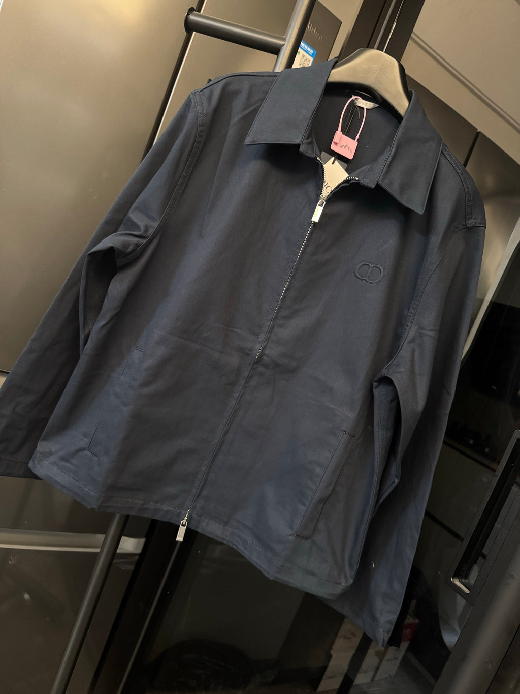 Dark navy long-sleeve zip jacket with pointed collar and small chest logo