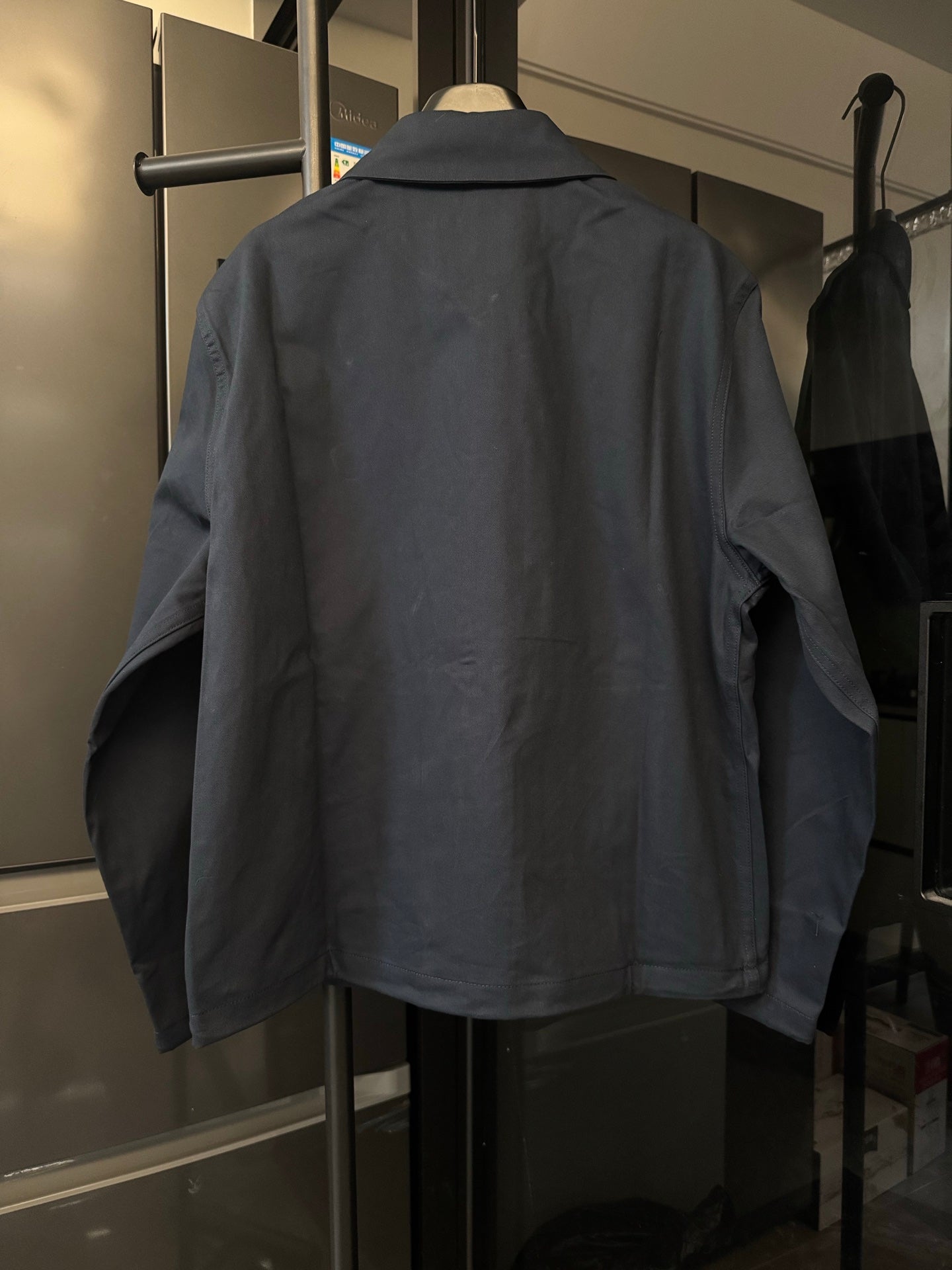 Dark navy jacket with pointed collar and full back view, front zip closure