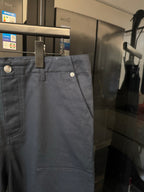 Dark blue trousers with belt loops and coin-style button at waistband