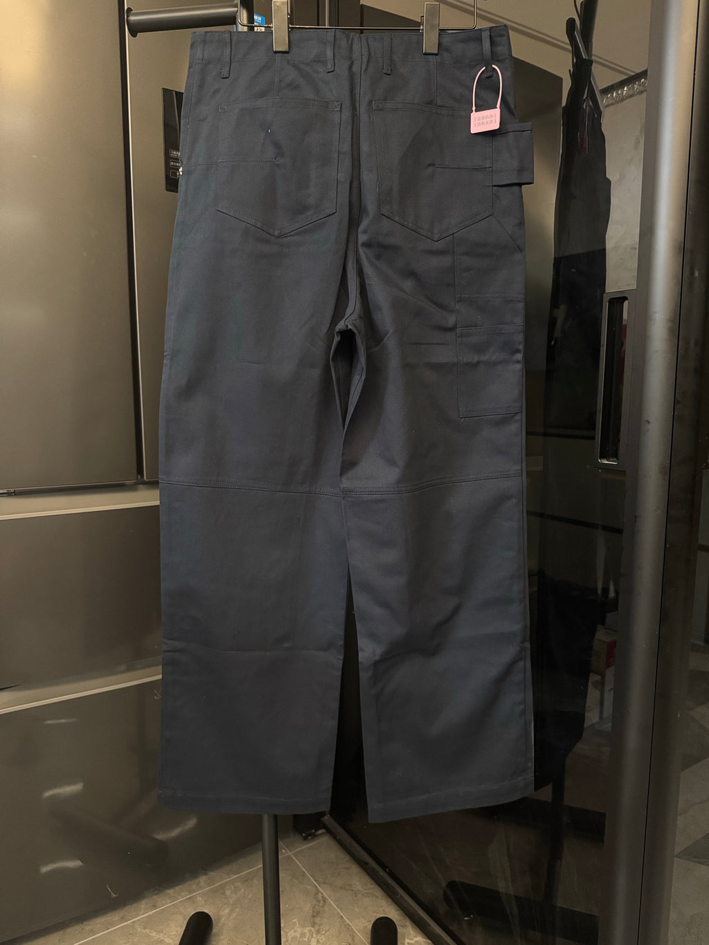 Dark blue cargo-style pants with flap pockets and belt loops