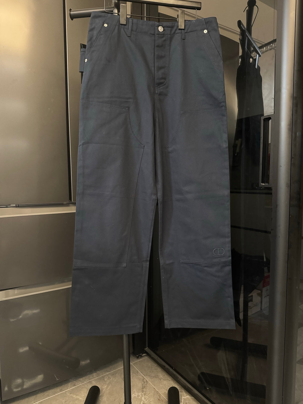 Navy blue straight-leg pants with button fly and belt loops