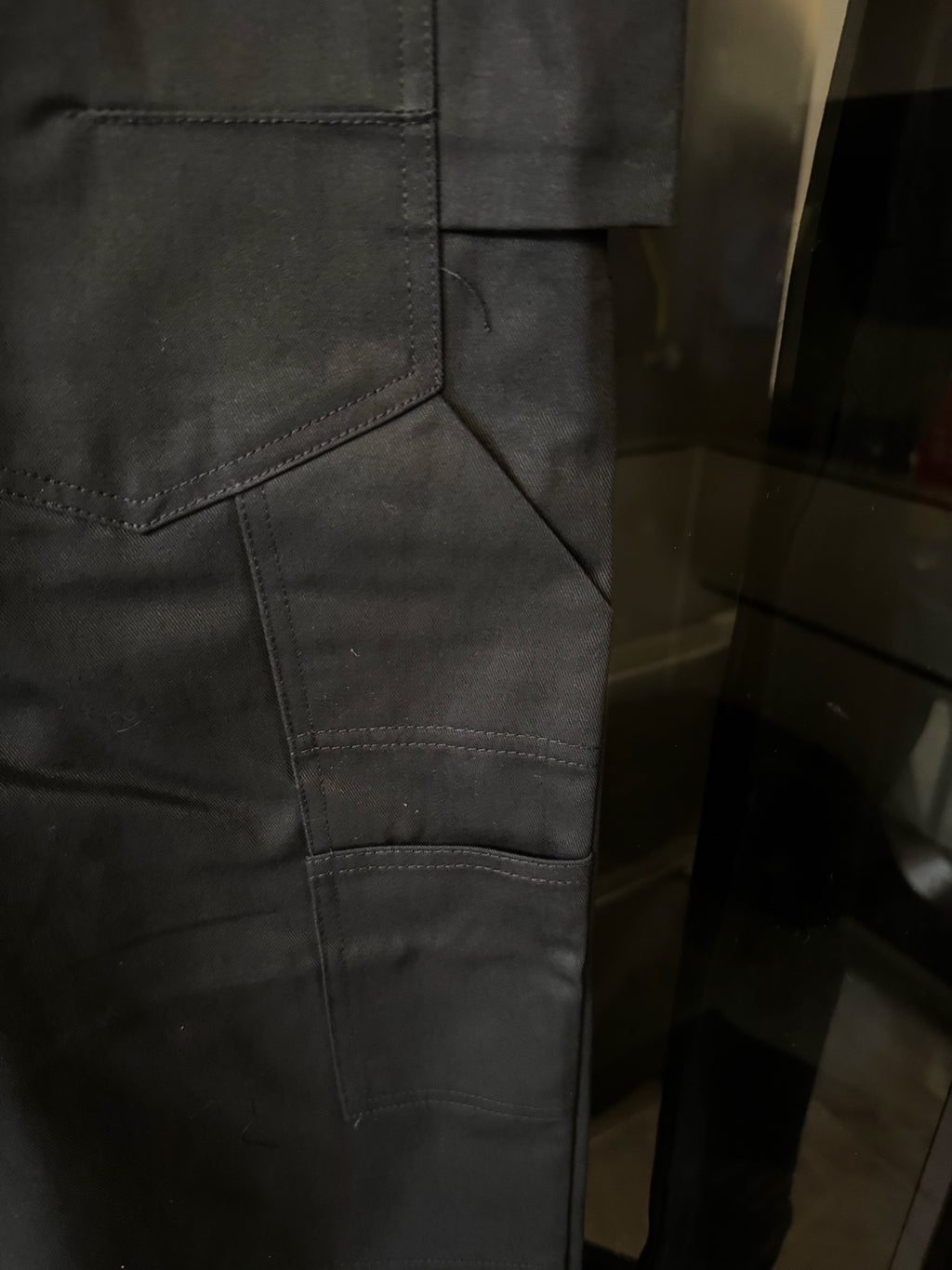 Dark blue pants close-up of stitched patch pocket and seams