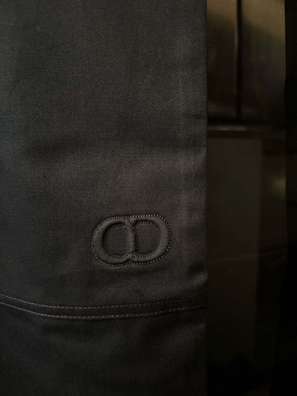 Embroidered circular Dior logo detail on dark blue pant pocket