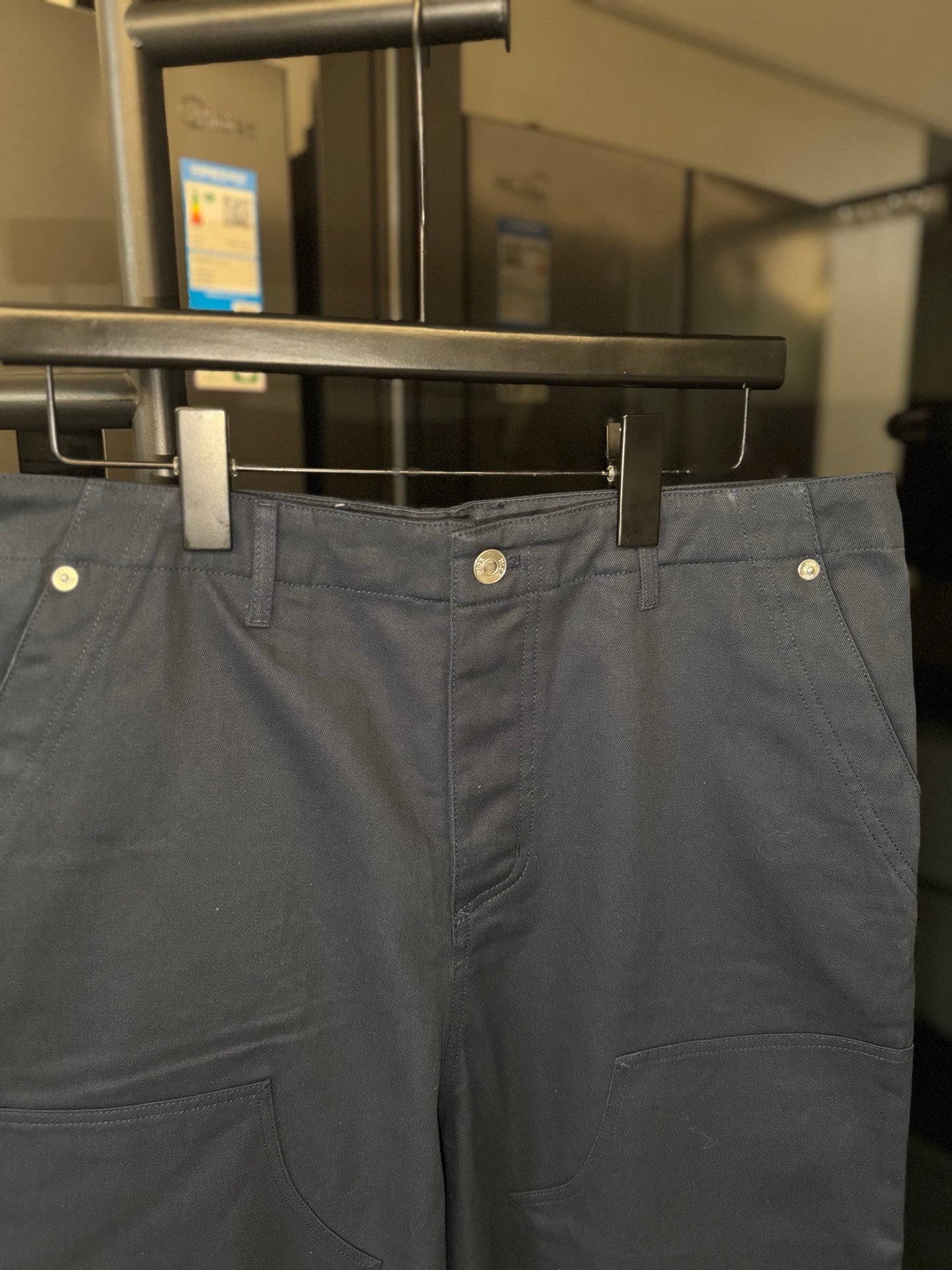 Dark blue chino pants with belt loops, front pleats, and side pockets
