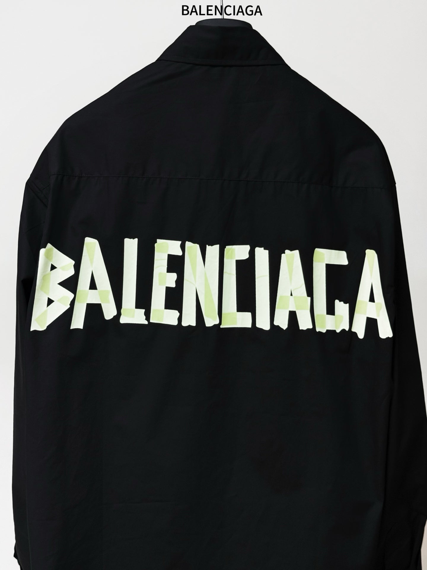 Black long-sleeve shirt with large BALENCIAGA logo print across back panel.