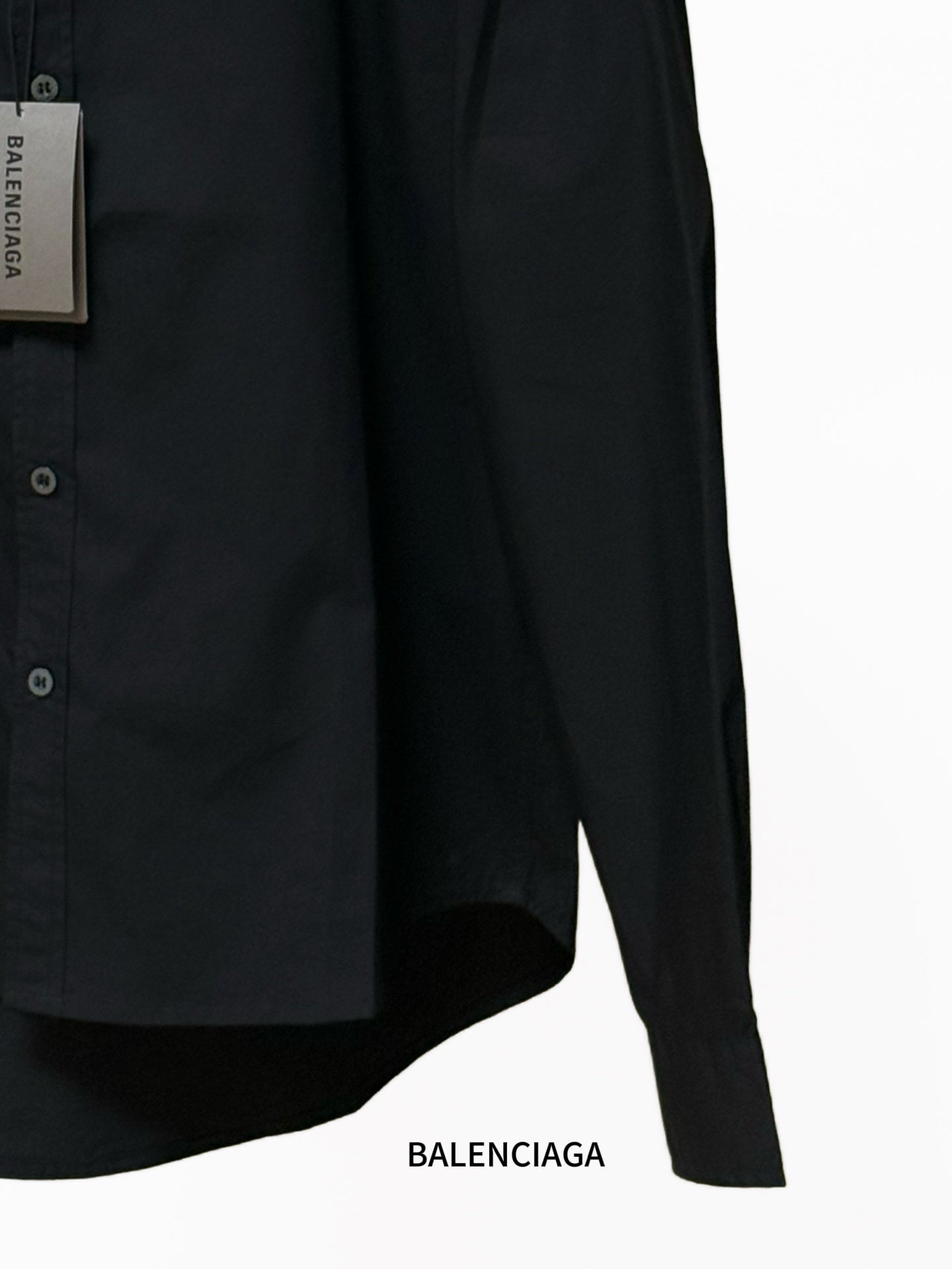 Balenciaga black long-sleeve shirt with front buttons and curved hem; close-up