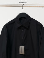 Balenciaga black long-sleeve button-up shirt on hanger with front button placket and tag