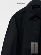 Balenciaga black long-sleeve shirt with pointed collar, button placket, and hanging tag
