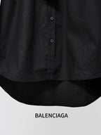 Black long-sleeve shirt close-up of front buttons and curved hem.