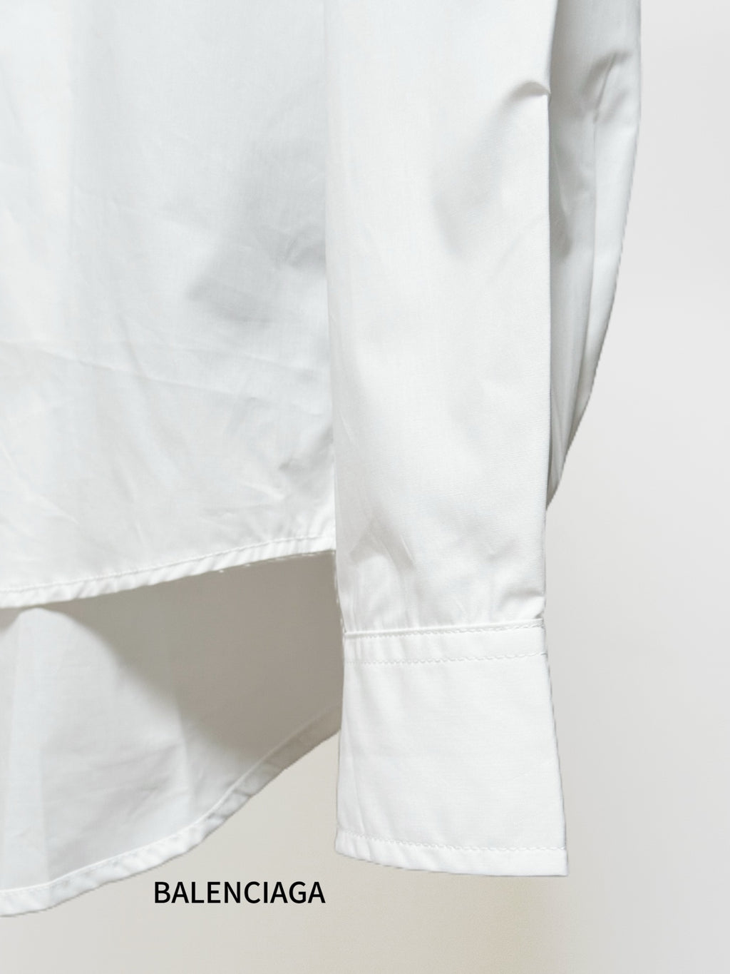 White shirt sleeve and side hem with stitched seam and cuff
