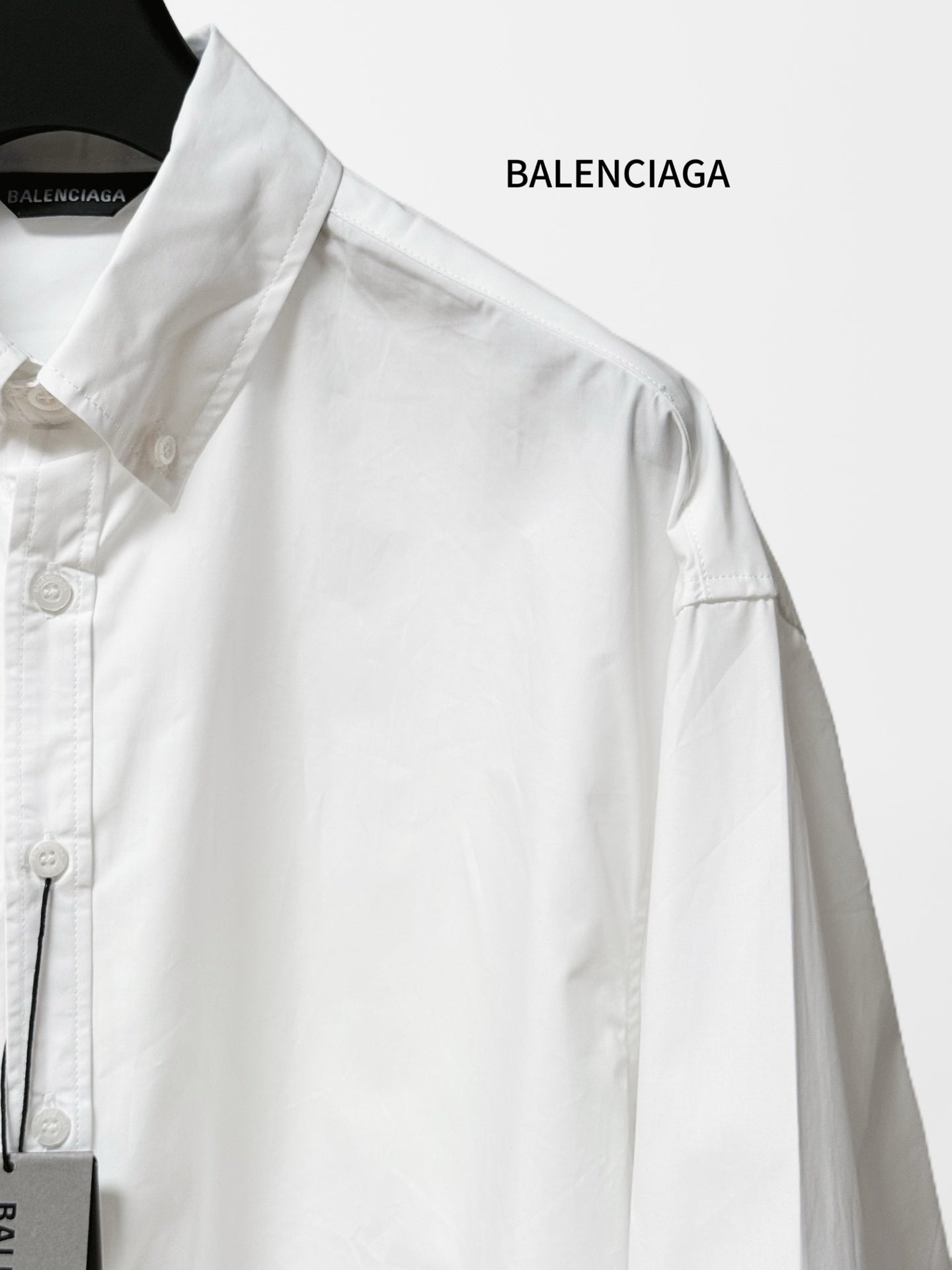 White long-sleeve shirt close-up of shoulder yoke and buttoned placket