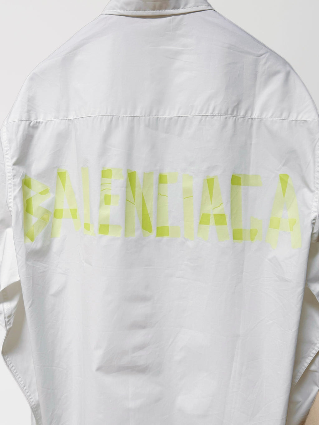White long-sleeve button-up shirt, back view with neon green graphic across yoke