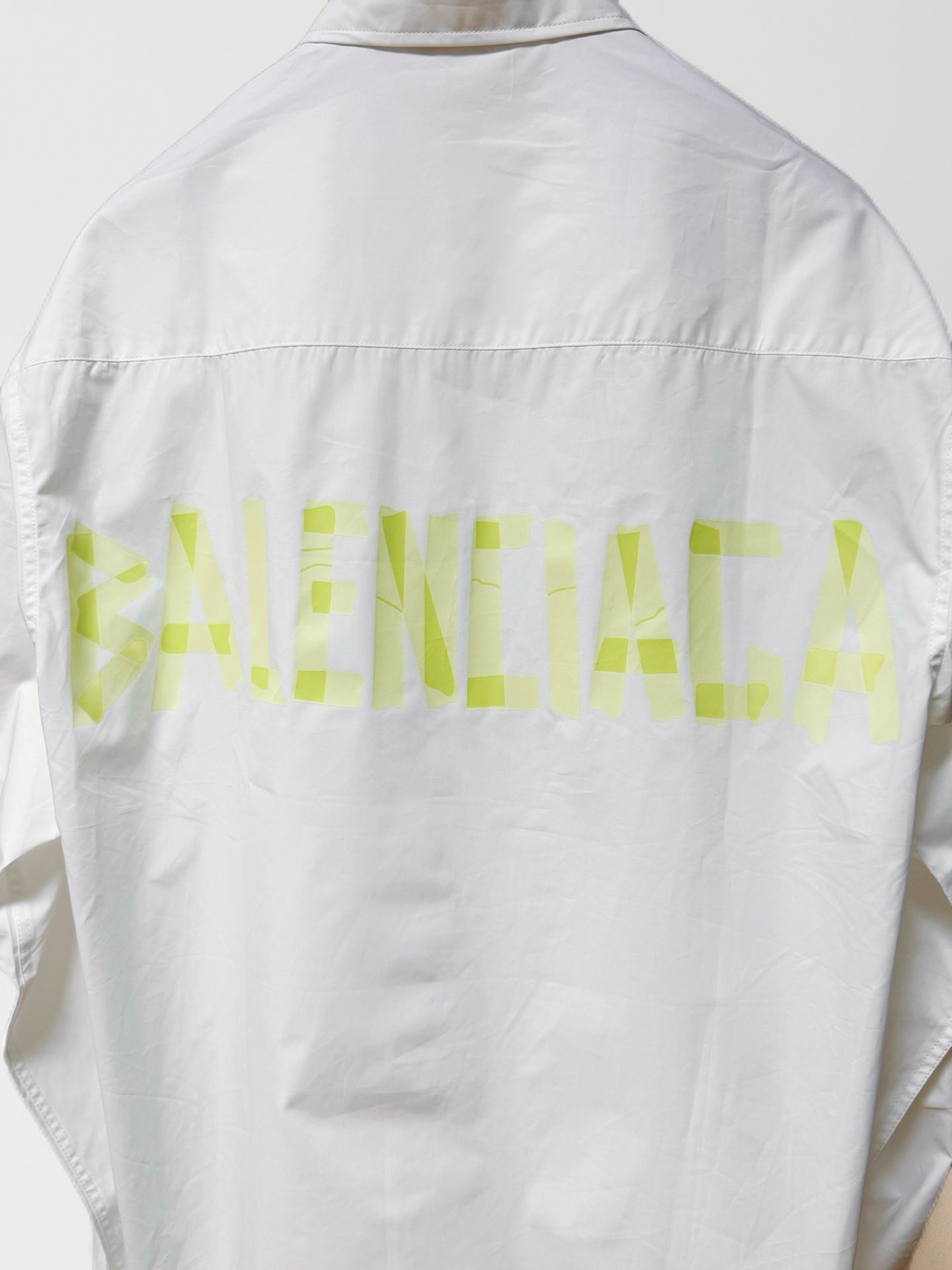 White long-sleeve button-up shirt, back view with neon green graphic across yoke