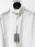 White button-up shirt with pointed collar, front button placket, hanging product tag