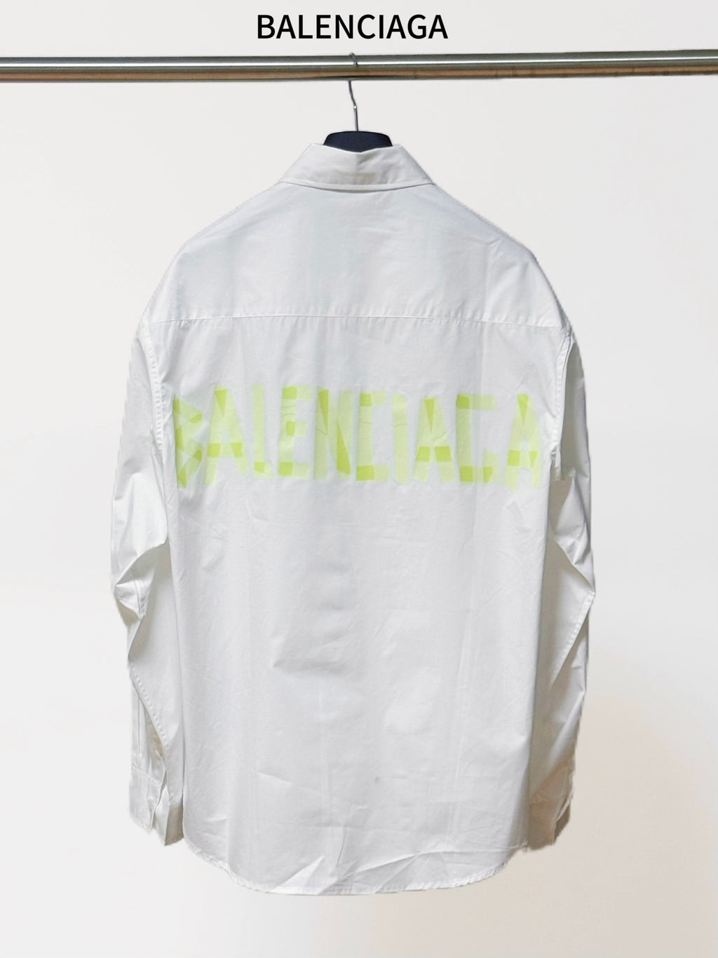 White long-sleeve button-up shirt, back view with neon green logo-style text
