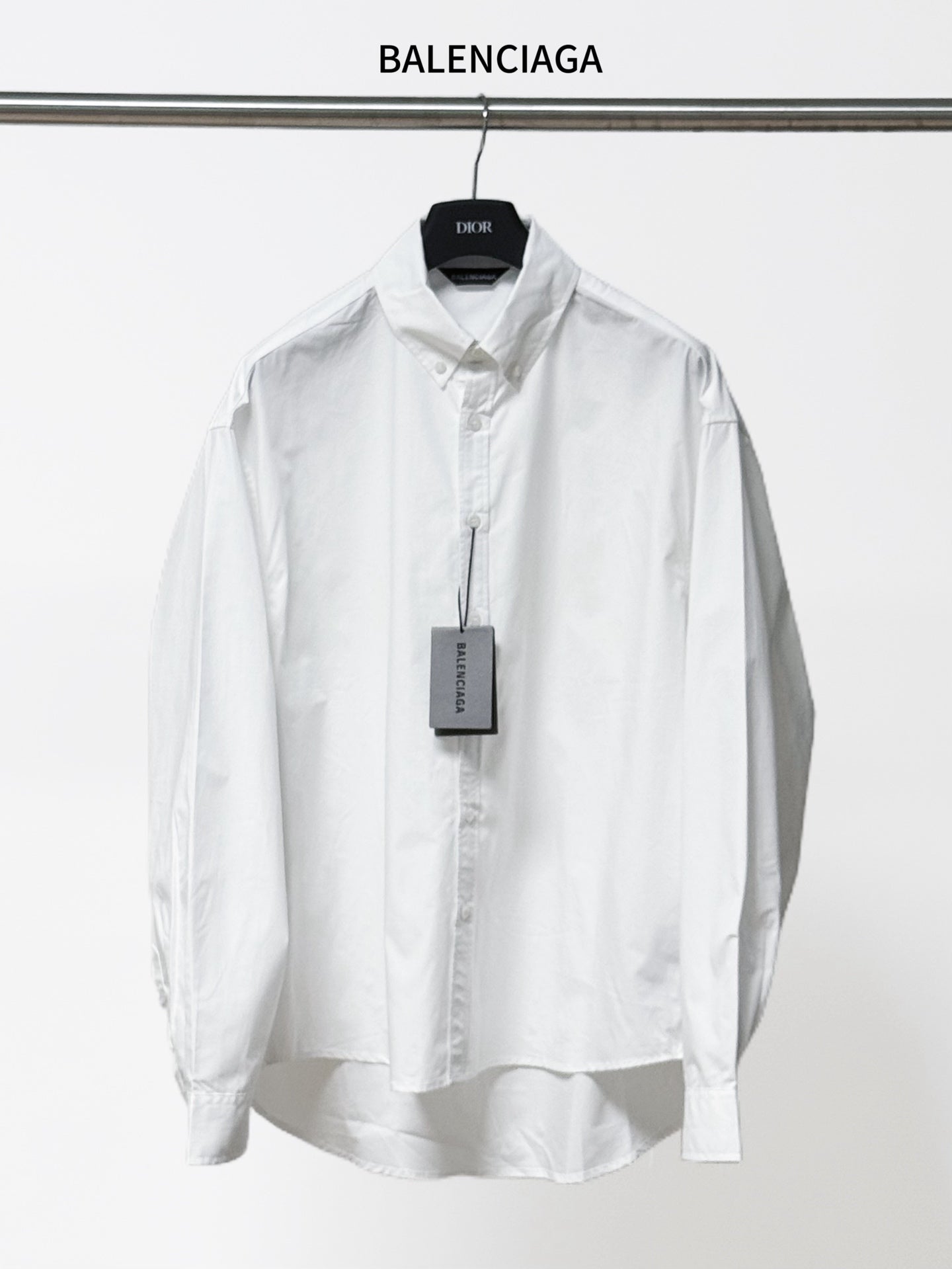White long-sleeve button-up shirt with pointed collar and button placket, front view