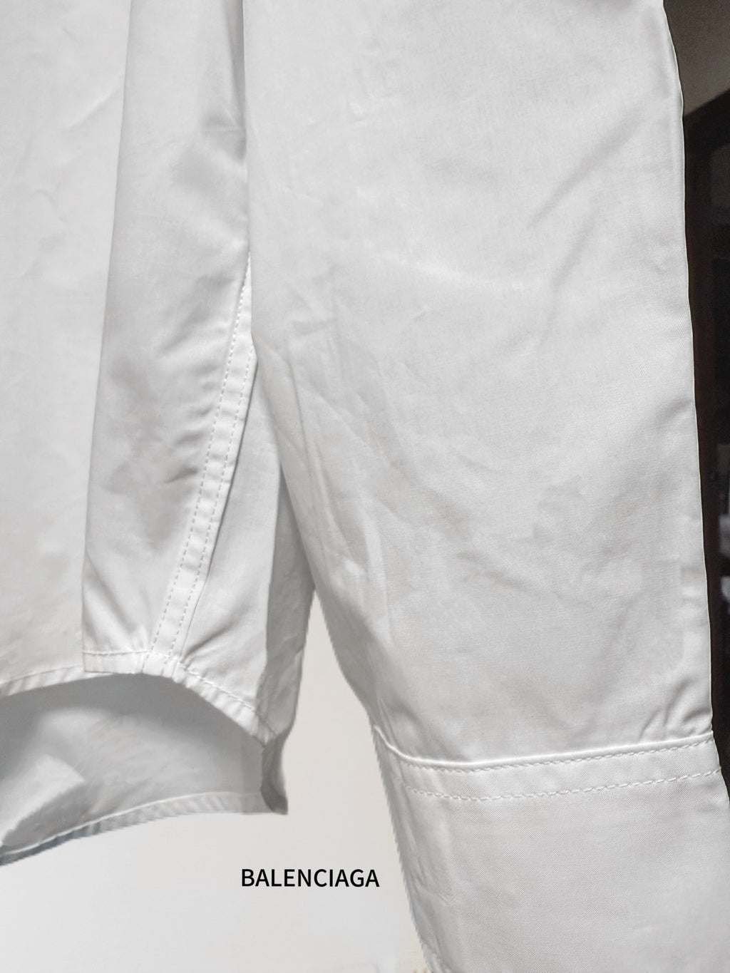 White button-up shirt bottom hem with side seam and stitched edge