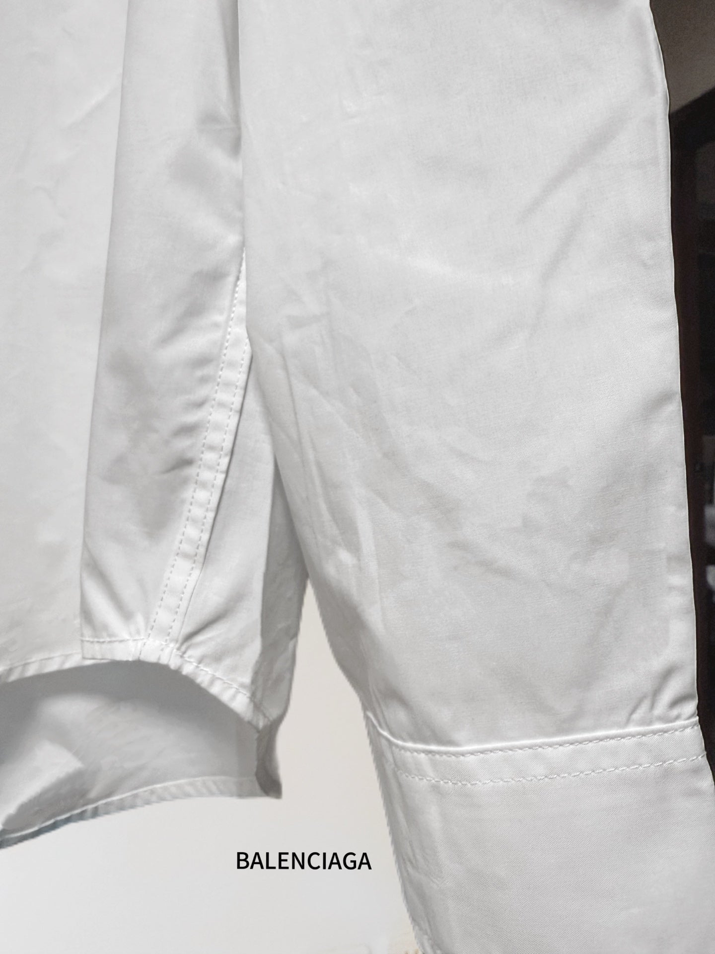 White button-up shirt bottom hem with side seam and stitched edge
