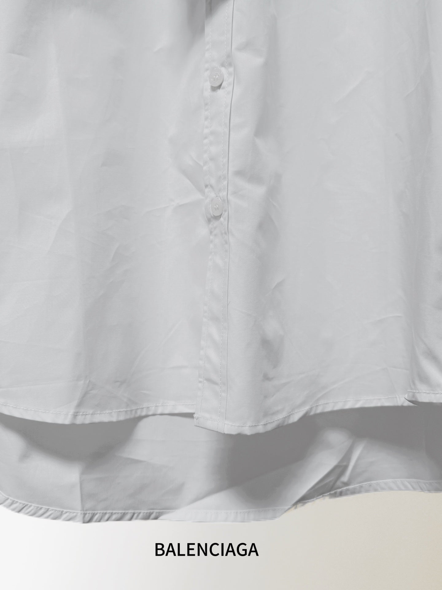 White button-up shirt front with button placket and curved hem
