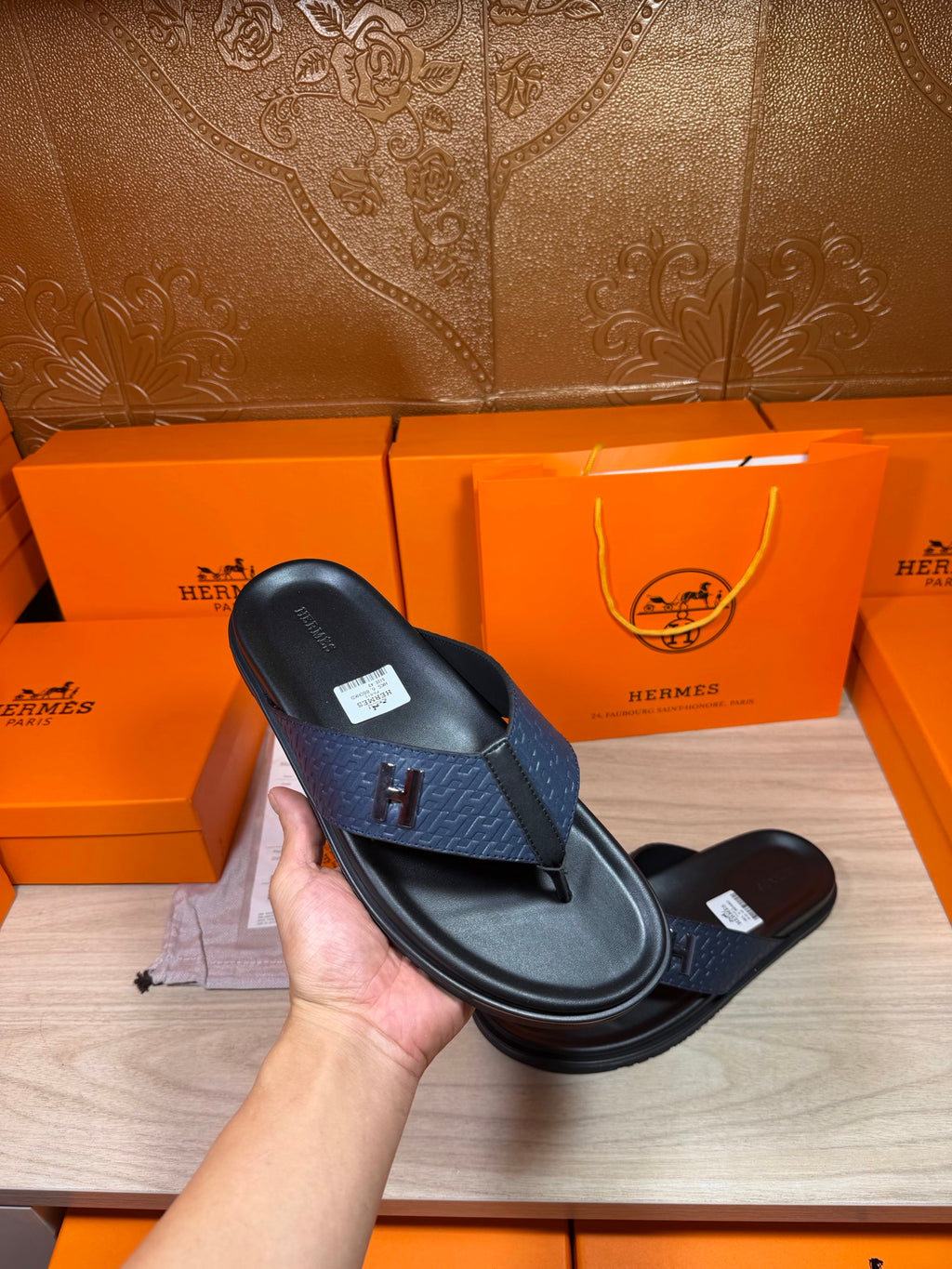 Luxury leather sandals held up, dark navy toe strap with black textured footbed