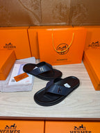 Luxury leather sandals with dark navy straps and black soles on display