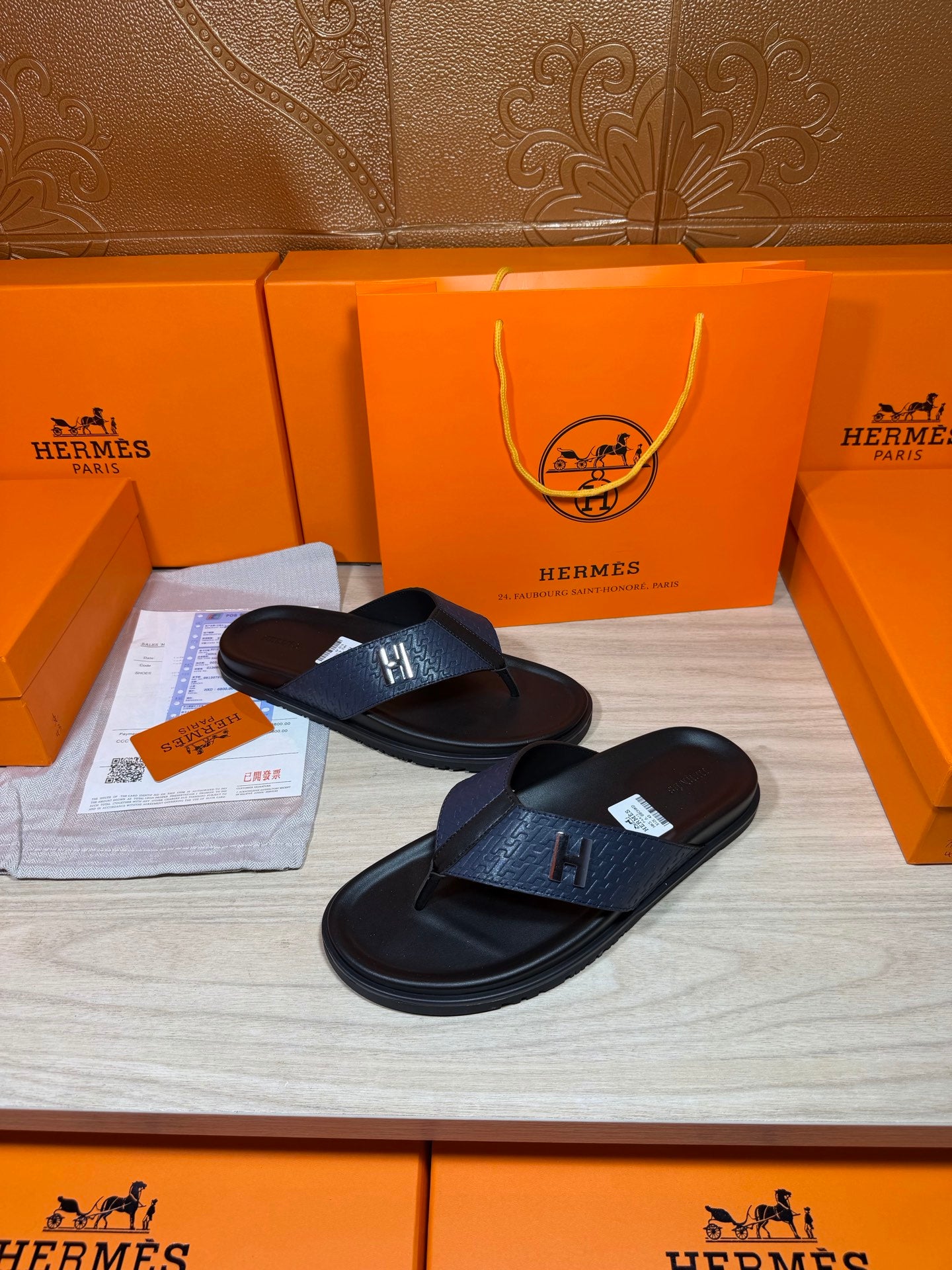 Luxury leather sandals with dark navy straps and black soles on display