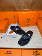Luxury leather sandals with dark navy H strap and black soles on display