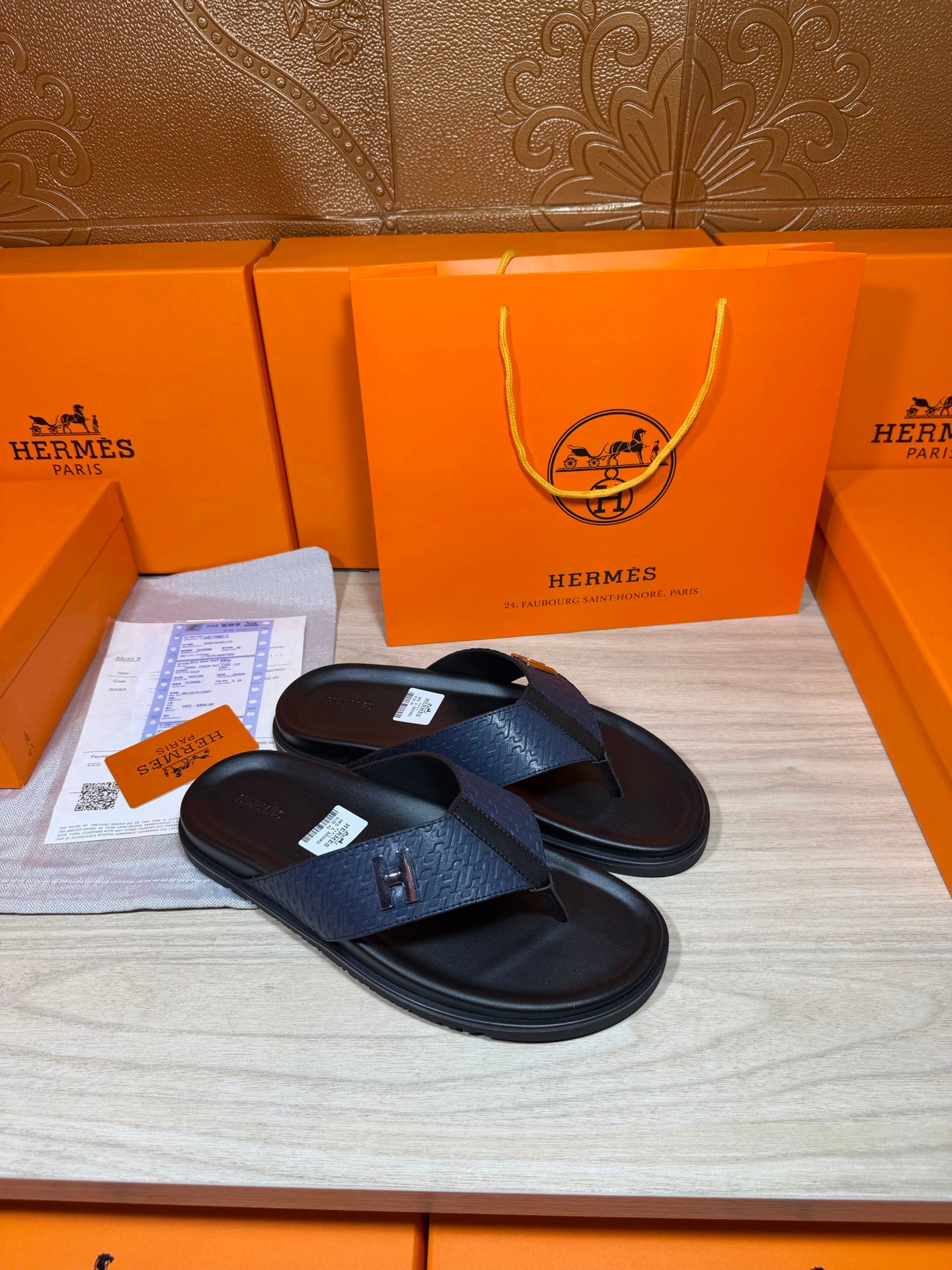 Luxury leather sandals with dark navy straps and black soles, shown as a pair