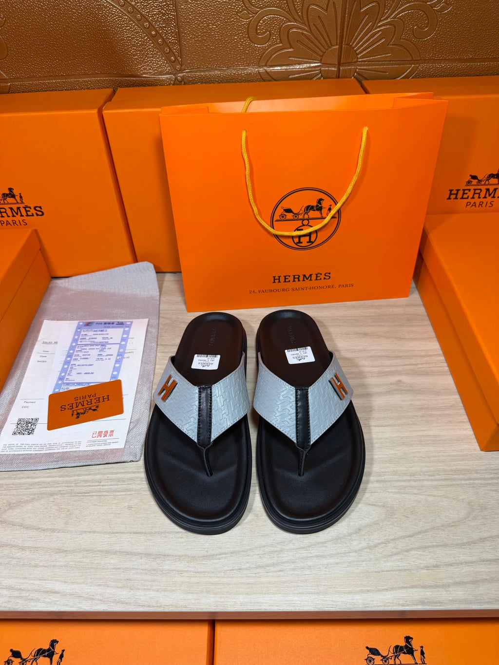 Black thong sandals with light gray strap and H logo on the footbed